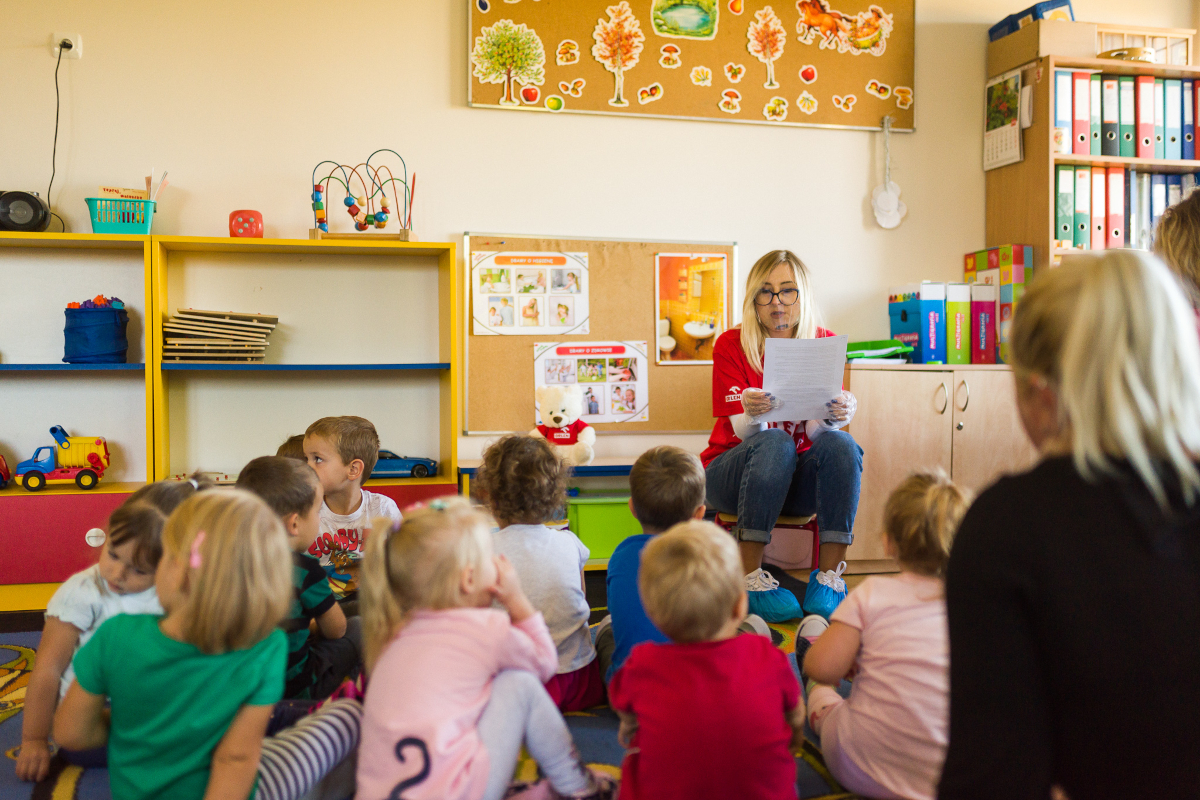ESG i wolontariat – Grupa ORLEN. Wolontariuszka Fundacji ORLEN czytająca książkę dzieciom w przedszkolu.