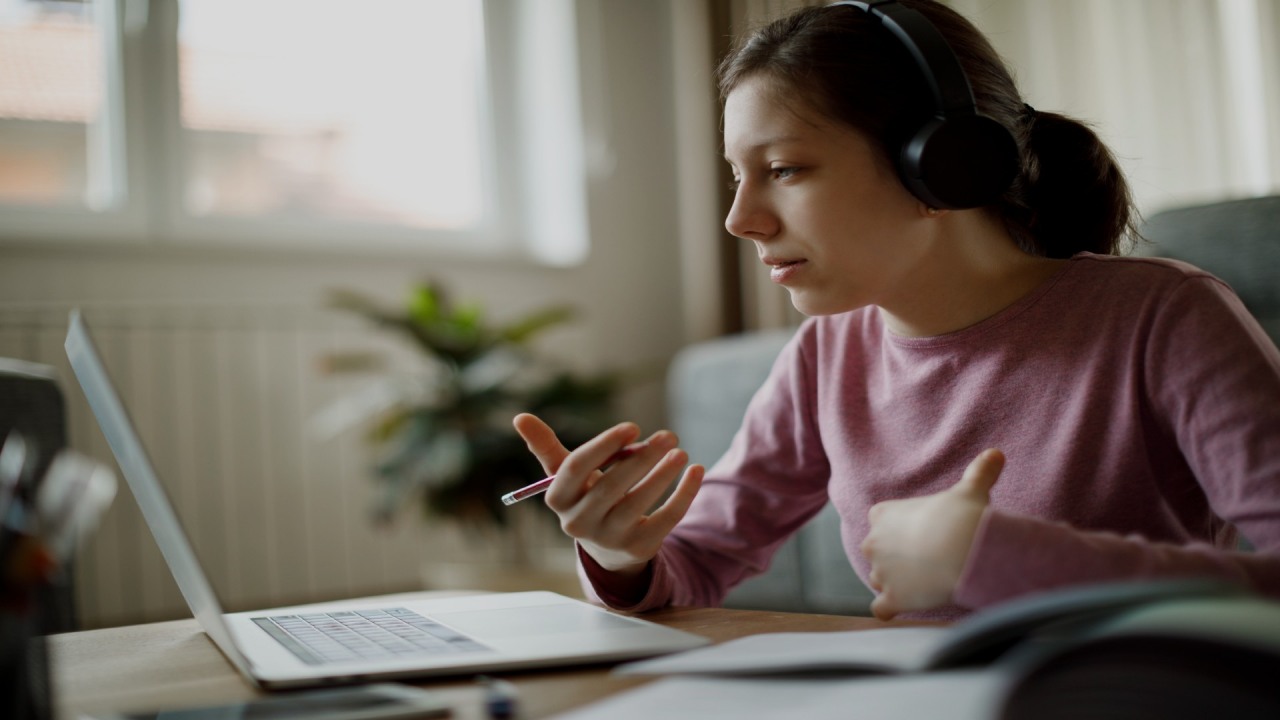 Fundacja ORLEN. Dziewczynka przy biurku w słuchawkach uczestniczy w lekcjach online